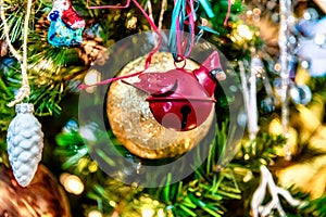 Beautiful closeup of red ornament and other decorations on a Christmas tree with lights