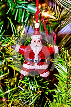 Beautiful closeup of a red Santa  ornament on a Christmas tree with lights