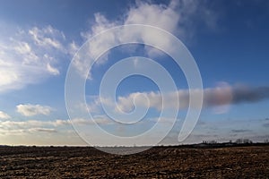 Beautiful clouds in a blue sky over a northern european agricutural field