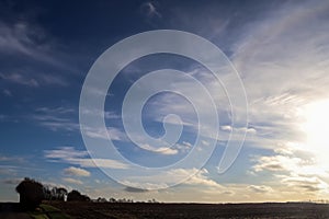 Beautiful clouds in a blue sky over a northern european agricutural field