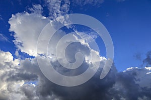 Beautiful clouds in the blue sky, the sun behind the cloud, a thunder cloud