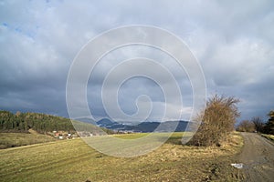 Krásné mraky nad zelenou loukou, cestami a stromy, při východu nebo západu slunce.