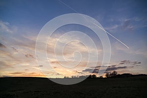 Beautiful clouds over the green meadow during sunrise or sunset.