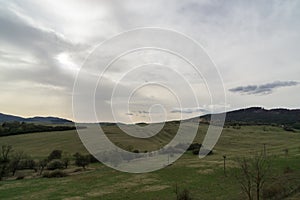 Beautiful clouds over the green meadow during sunrise or sunset.