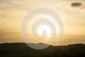 Beautiful clouds over the green meadow during sunrise or sunset.