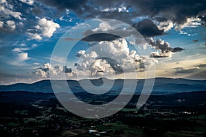 Beautiful clouds with the sun penetrating them during sunset over the Karkonosze Mountains.