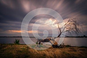 Beautiful cloudscape long exposure near the lake with a wooden l