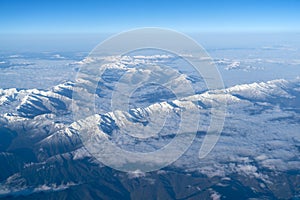 Beautiful cloudscape and snow mountains from plane window