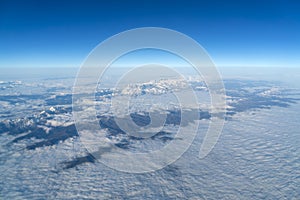 Beautiful cloudscape and snow mountains from plane window