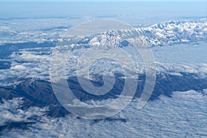 Beautiful cloudscape and snow mountains from plane window