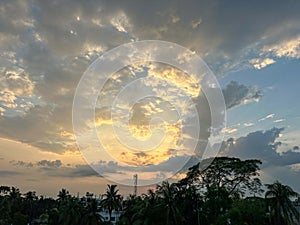 Beautiful cloudy sky and sunset view in a rural area. Scenic sunset view with thick clouds and sunbeams coming out from the clouds