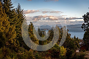 Beautiful cloudy sunset view of the lake Nahuel Huapi, its islands and mountains in the background, surrounded by