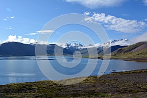 Beautiful coast of the fjord at the forefront of the snowy peaks in the west of Iceland