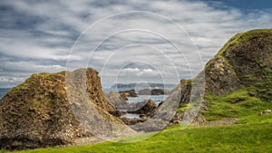 Beautiful coastline with hills, cliffs and small rocky islands on Causeway Coast