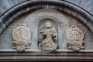 Beautiful coat of arms and statue on a historical old building