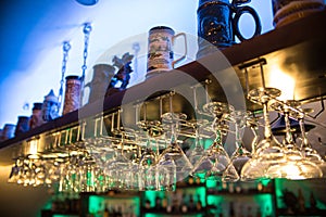 Beautiful cocktail glasses in the bar hang over the table. Nightclub. Alcoholic beverages, many wine glasses have different shapes