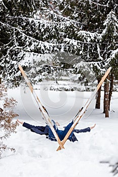 Beautiful cold forest view and skier wearing in skis that lying and relaxing after skiing. Winter day on a slope, pist