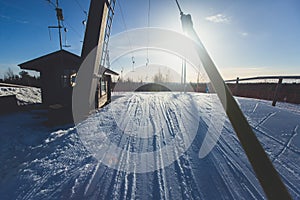 Beautiful cold mountain view of ski resort, sunny winter day with slope, piste and ski lift, with group of mountain downhill