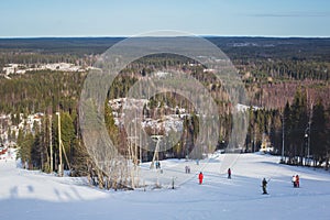 Beautiful cold mountain view of ski resort, sunny winter day with slope, piste and ski lift, with group of mountain downhill