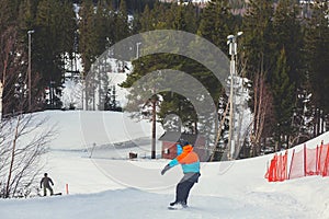 Beautiful cold mountain view of ski resort, sunny winter day with slope, piste and ski lift, with group of mountain downhill