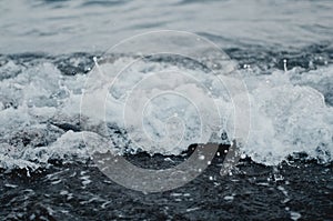 Beautiful cold sea waves run ashore. Sea foam