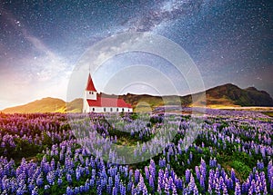 Beautiful collage Lutheran Church in Vik under fantastic starry sky. Iceland