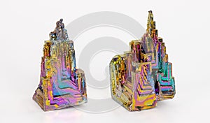 Beautiful colored brittle bismuth hopper crystals with stairstep structure on a white background