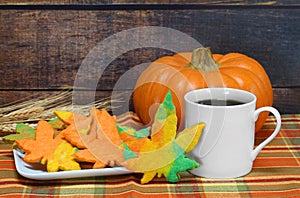 Beautiful colored leaf shaped cookies with coffee in an Autumn setting