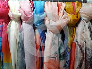 Beautiful Colored woman& x27;s scarves tied knot to the rack hanging in store.