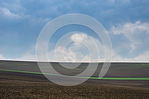 Beautiful and colorful abstract landscape, with rolling hills, green wheat fields and yellow rape fields in South Moravia, Czech