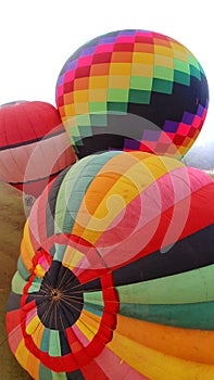 Beautiful colorful balloons on the ground while being inflate with hot air