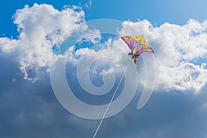Beautiful colorful butterfly kite against the sky and clouds, freedom vacation travel concept