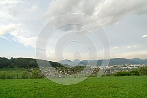 Beautiful colorful clouds over the green meadow during sunrise or sunset.