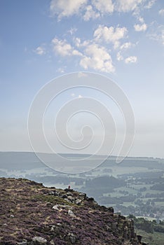 Beautiful colorful English Peak District landscape from Curbar Edge of colorful heather during late Summer sunset