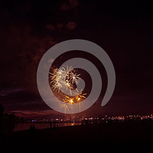 Beautiful, colorful fireworks above the river during an Independence day