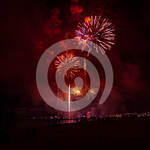 Beautiful, colorful fireworks above the river during an Independence day