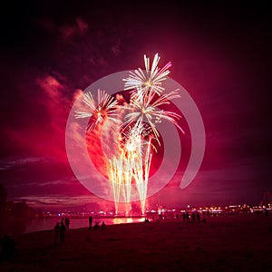 Beautiful, colorful fireworks above the river during an Independence day