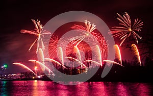 Beautiful, colorful fireworks above the river during an Independence day