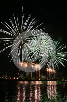 Beautiful, colorful fireworks above the river during an Independence day