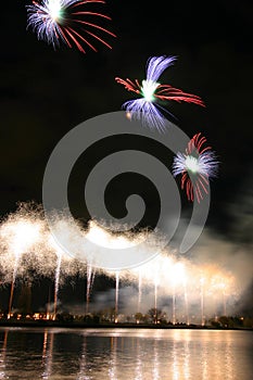 Beautiful, colorful fireworks above the river during an Independence day