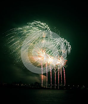 Beautiful, colorful fireworks above the river during an Independence day