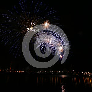 Beautiful, colorful fireworks above the river during an Independence day