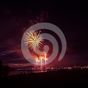 Beautiful, colorful fireworks above the river during an Independence day