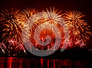 Beautiful, colorful fireworks above the river during an Independence day