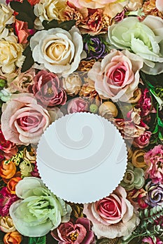 Beautiful colorful flowers wall background, with white circle greeting card with copy space; Spring, wedding, anniversary or flori