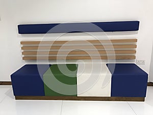 A Beautiful colorful four seating sofa with wall mounted wooden back with cushion for the waiting at reception area of an big