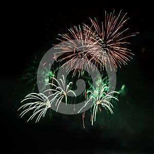 Beautiful colorful holiday fireworks on the black sky background, long exposure