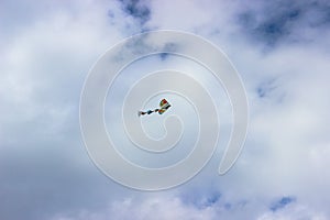 Beautiful colorful kite flying in a blue cloudy sky