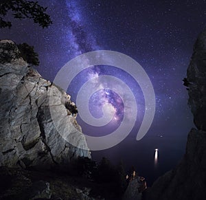 Beautiful colorful night landscape with Milky Way, rocks, sea and starry sky. Mountain landscape. Amazing universe.