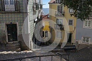 Beautiful and colorful old buildings in the Alfama Neighbourhood and the Tagus River on the background on a sunny day